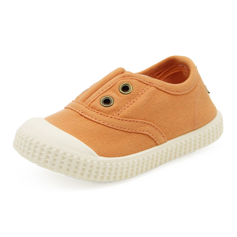 Orange children's shoe with a white sole on a white background