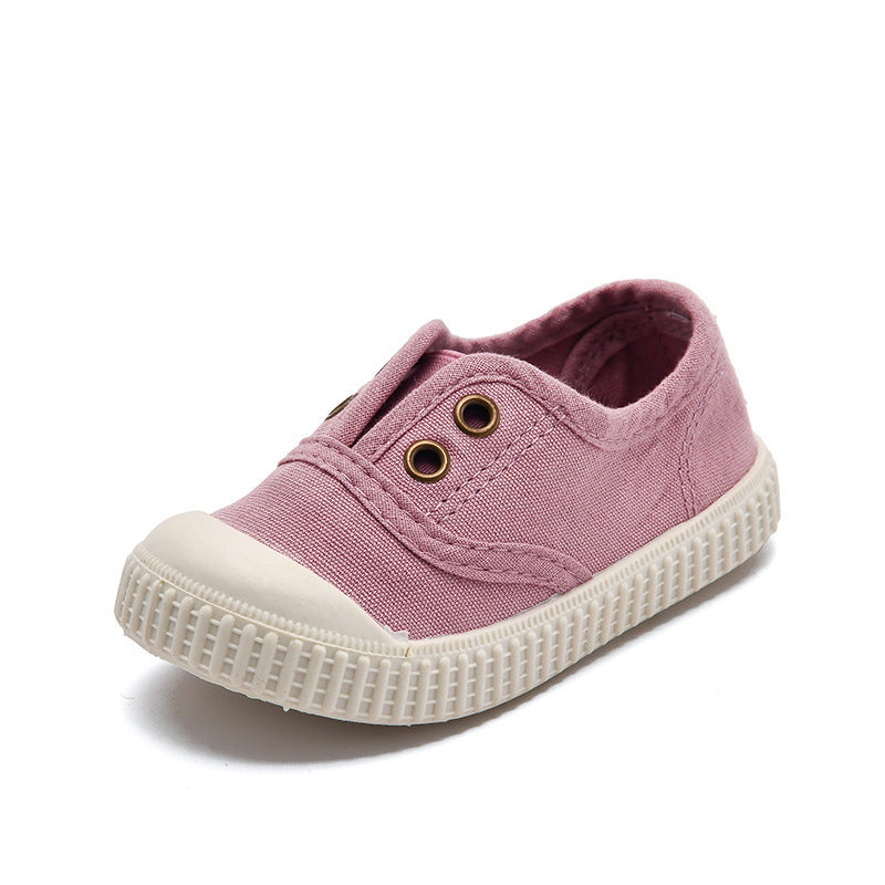 Pink children's sneaker with white sole on a white background