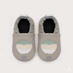 Pair of gray baby shoes with a decorative patch on a white background