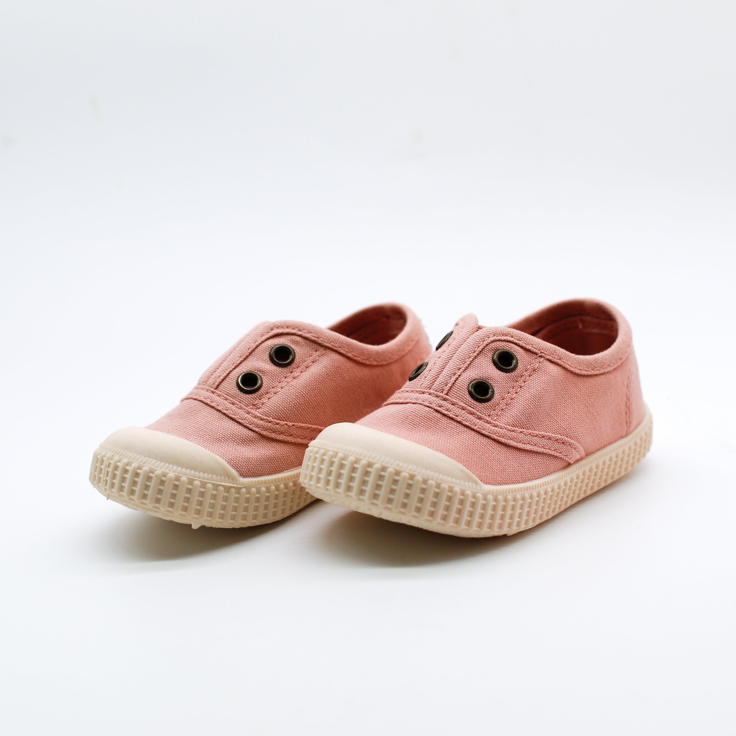 Pair of pink children's shoes on a white background