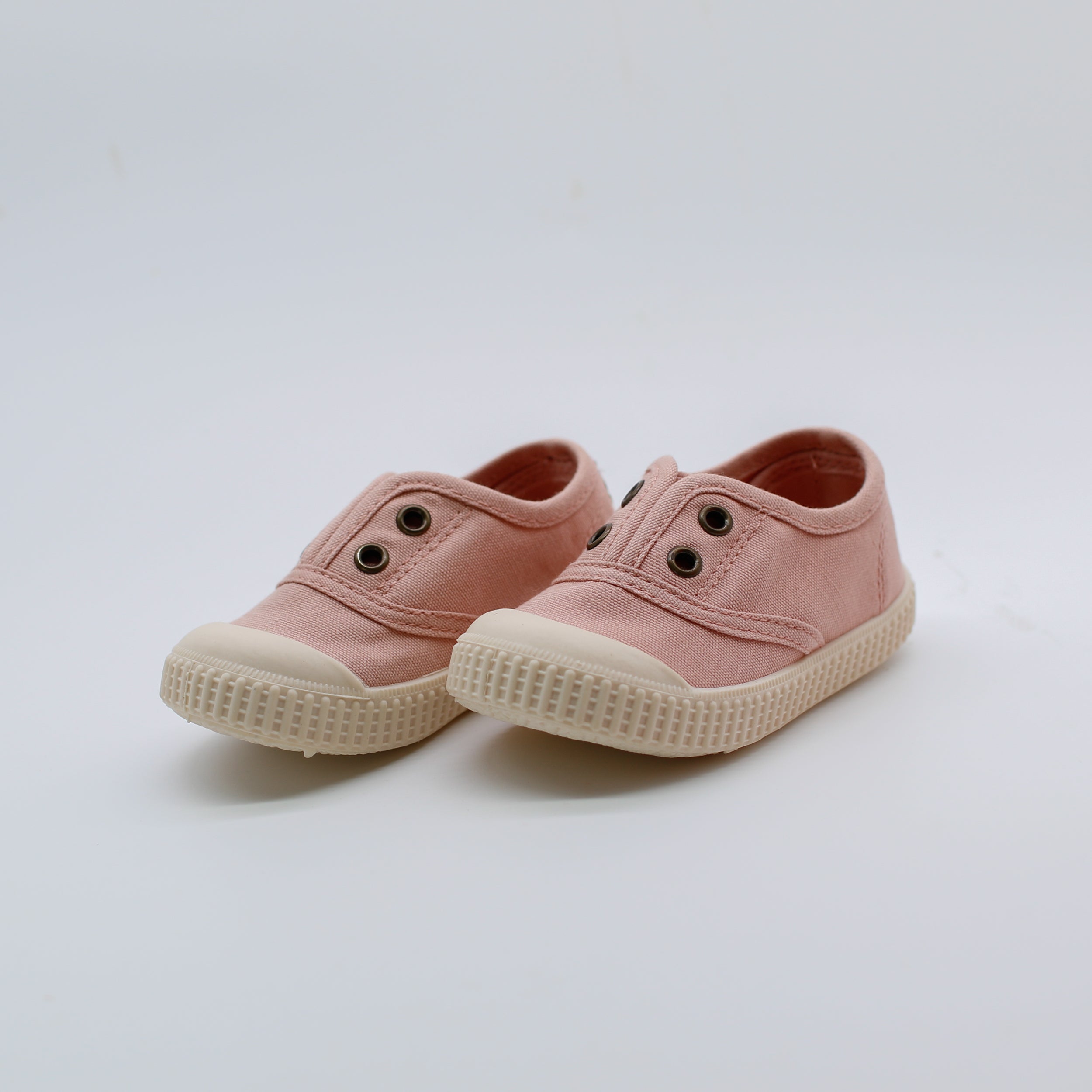 Pair of pink children's shoes on a light gray background