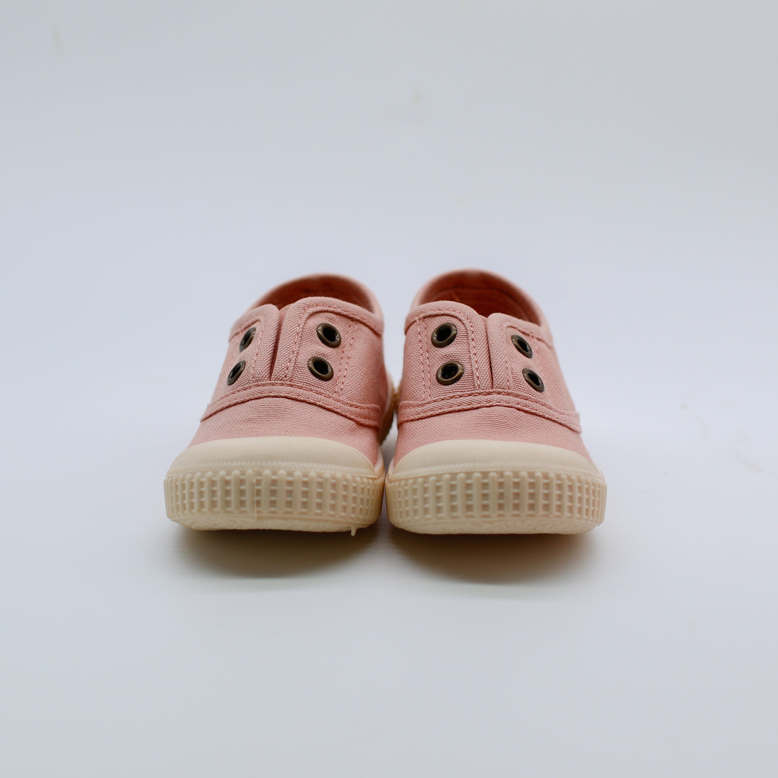 Pair of pink children's shoes on a white background