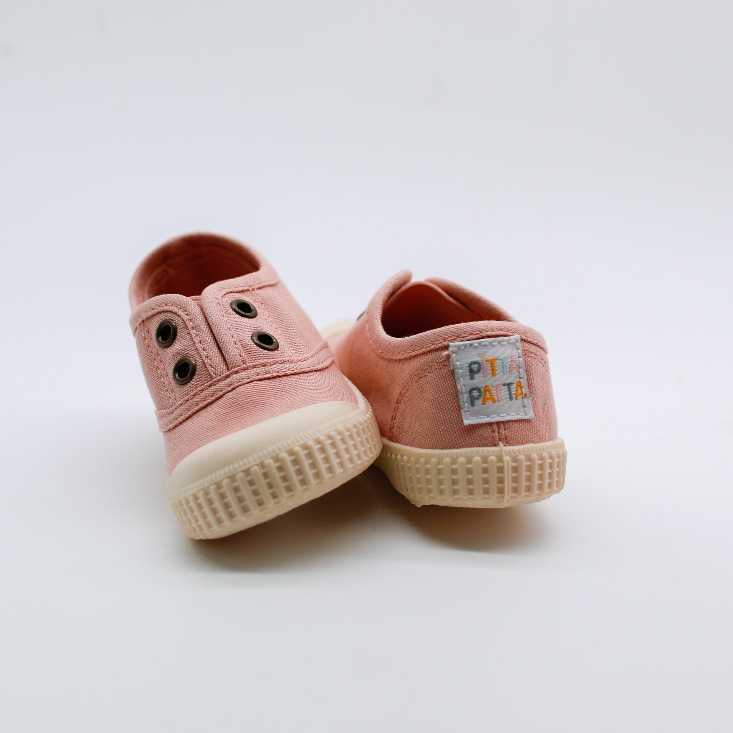Pair of pink children's shoes with a visible brand label on a white background