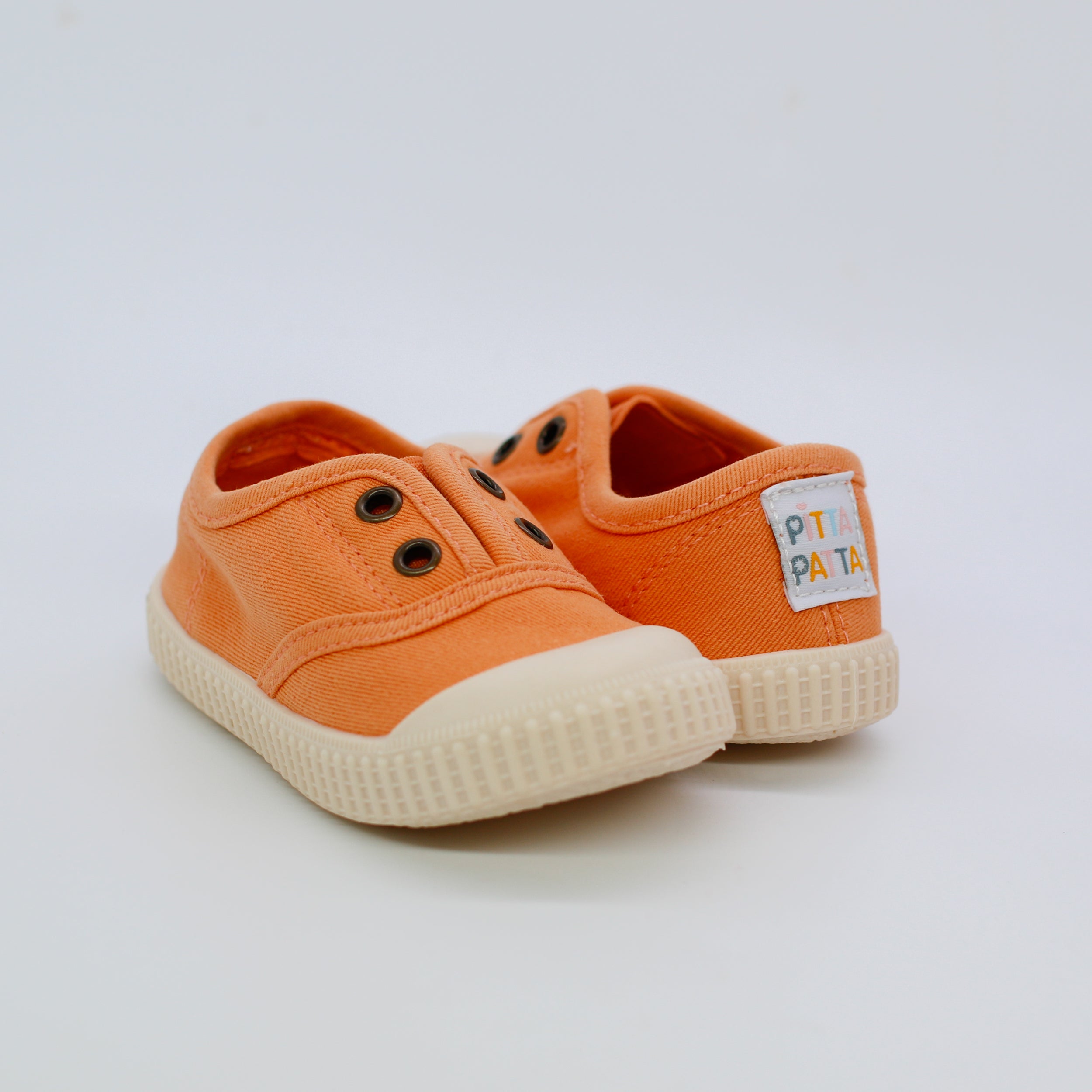 Orange children's shoes with a visible brand label on a white background