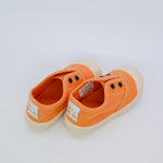 Pair of orange children's shoes on a white background