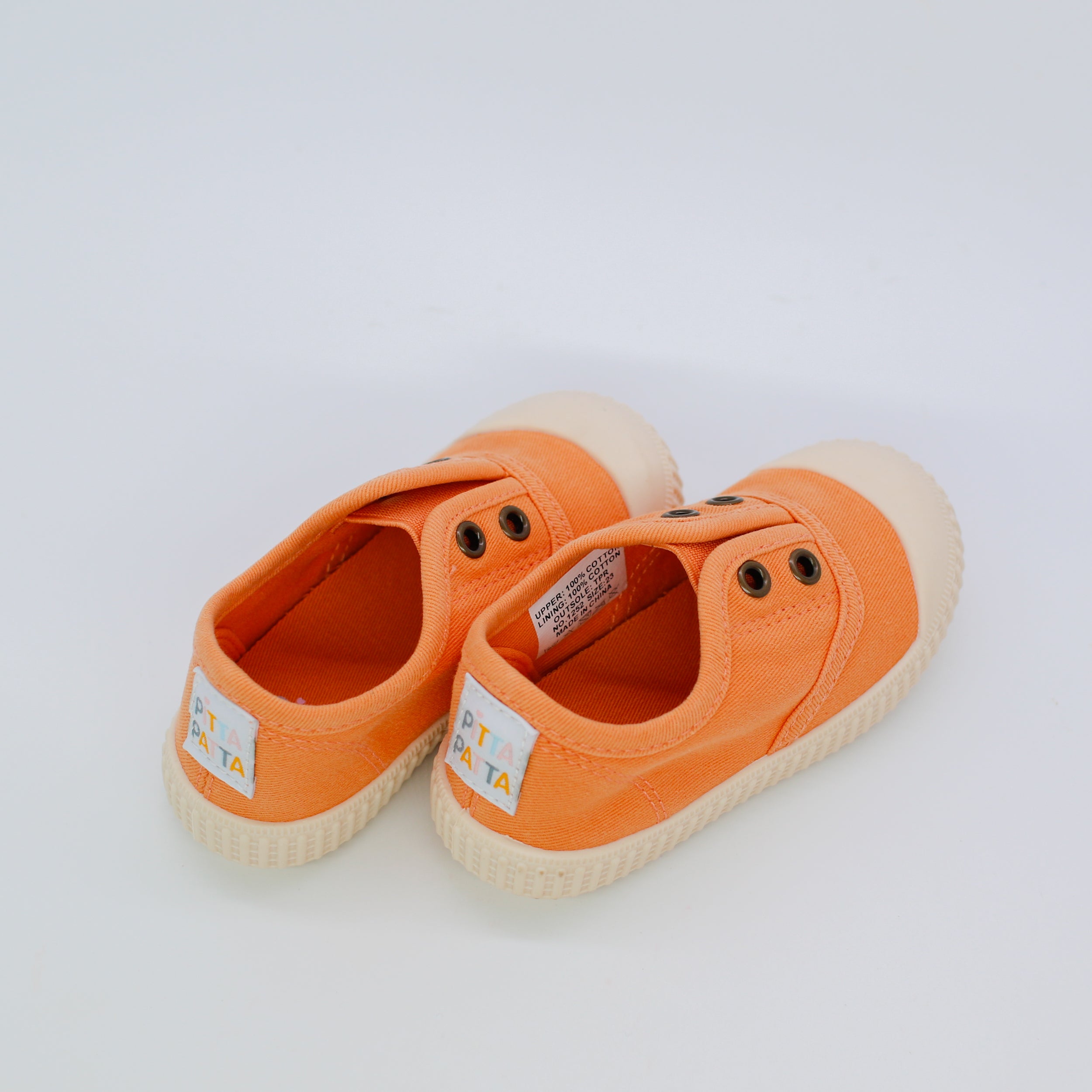 Pair of orange children's shoes on a white background