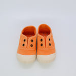 Pair of orange children's sneakers on a light gray background