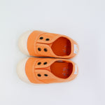 Pair of orange children's shoes on a white background