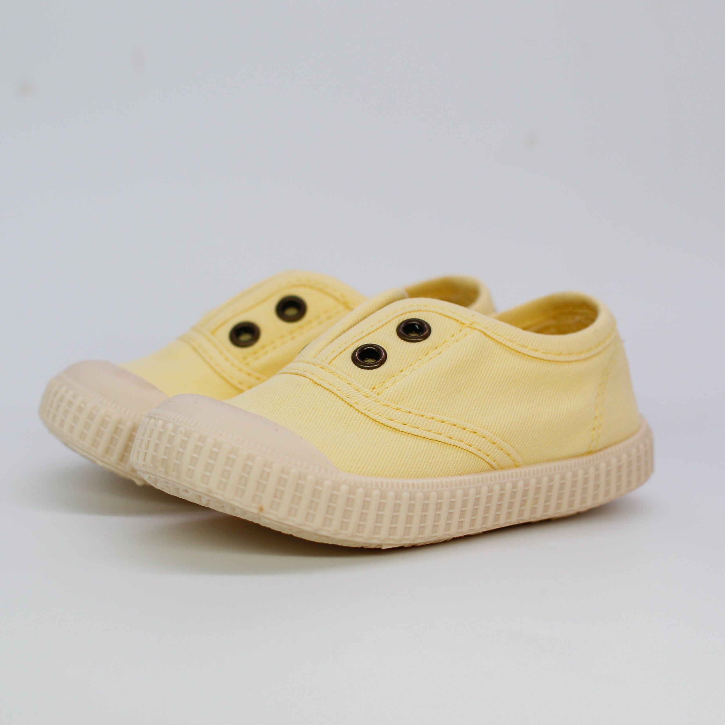 Yellow children's shoe on a light gray background