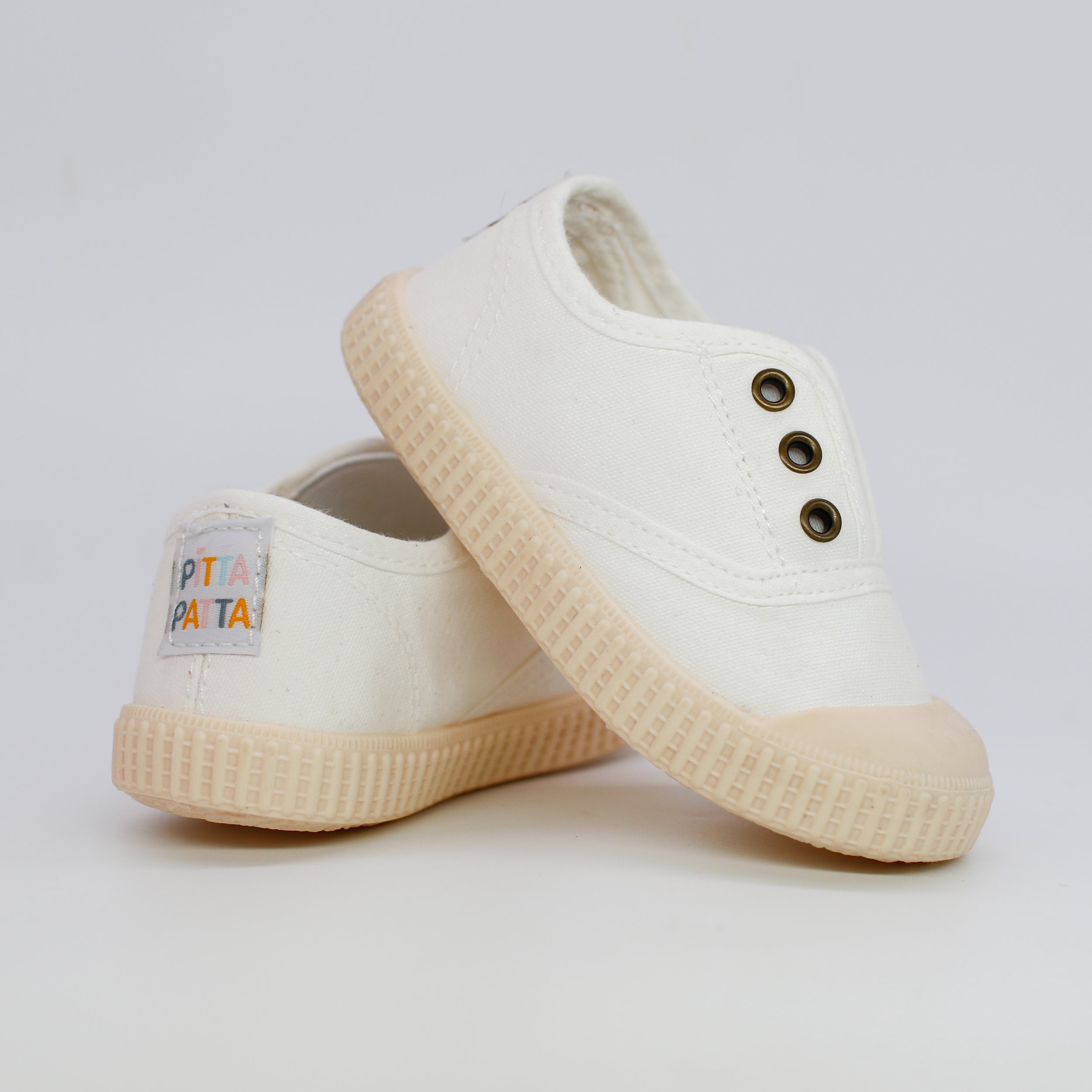 White sneakers with a brand label on a light gray background