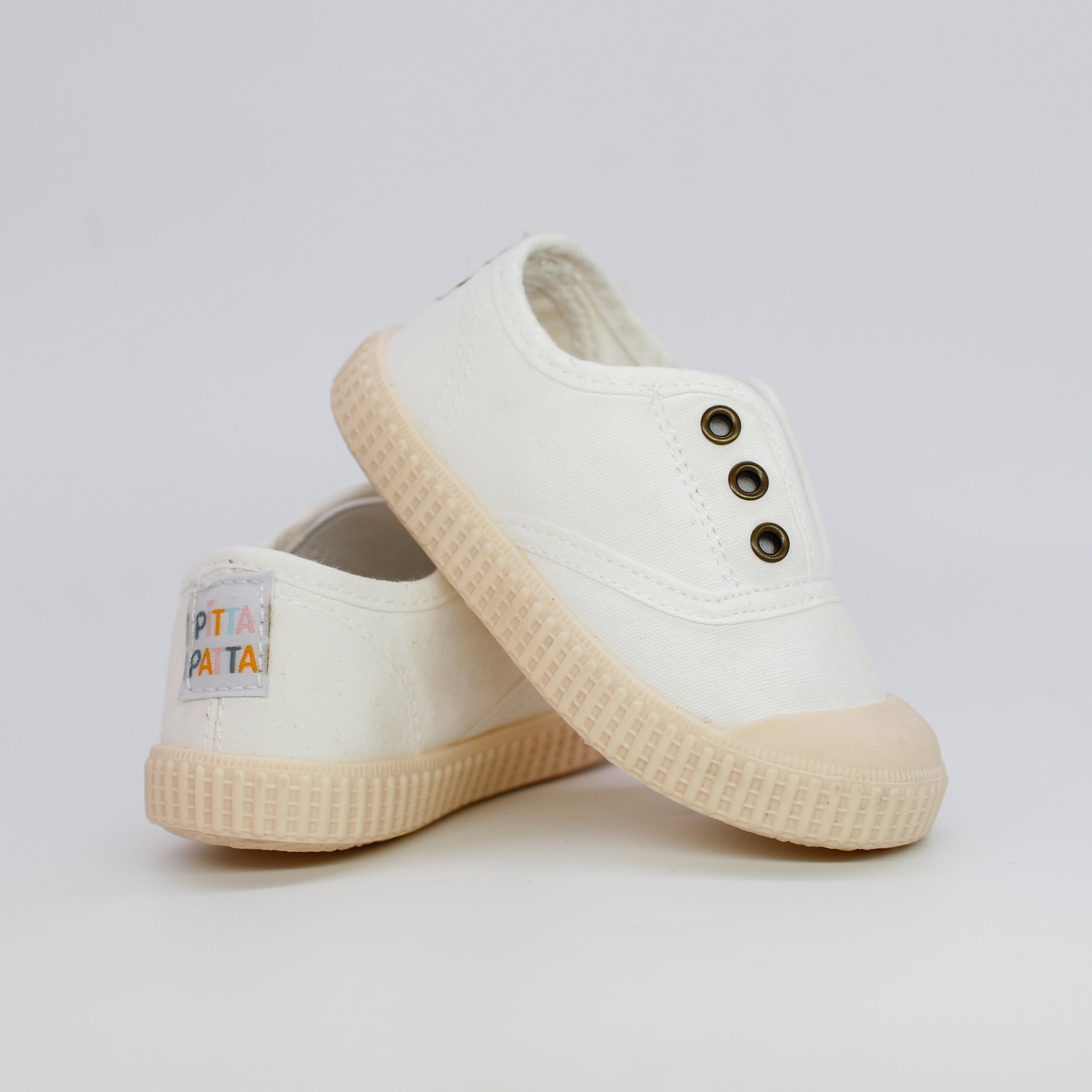 White sneakers with a brand label on a light gray background