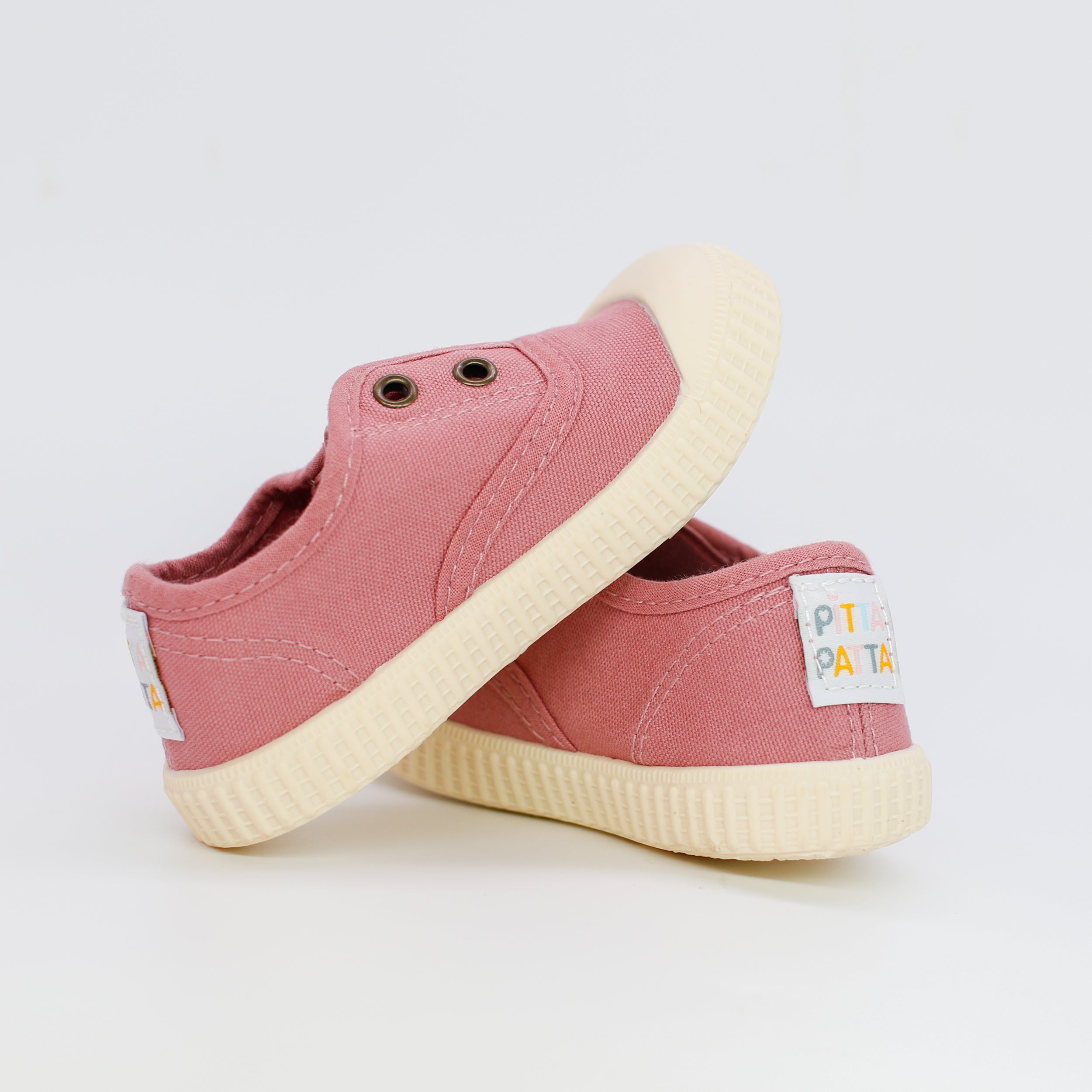 Pair of pink children's sneakers with white soles on a light gray background