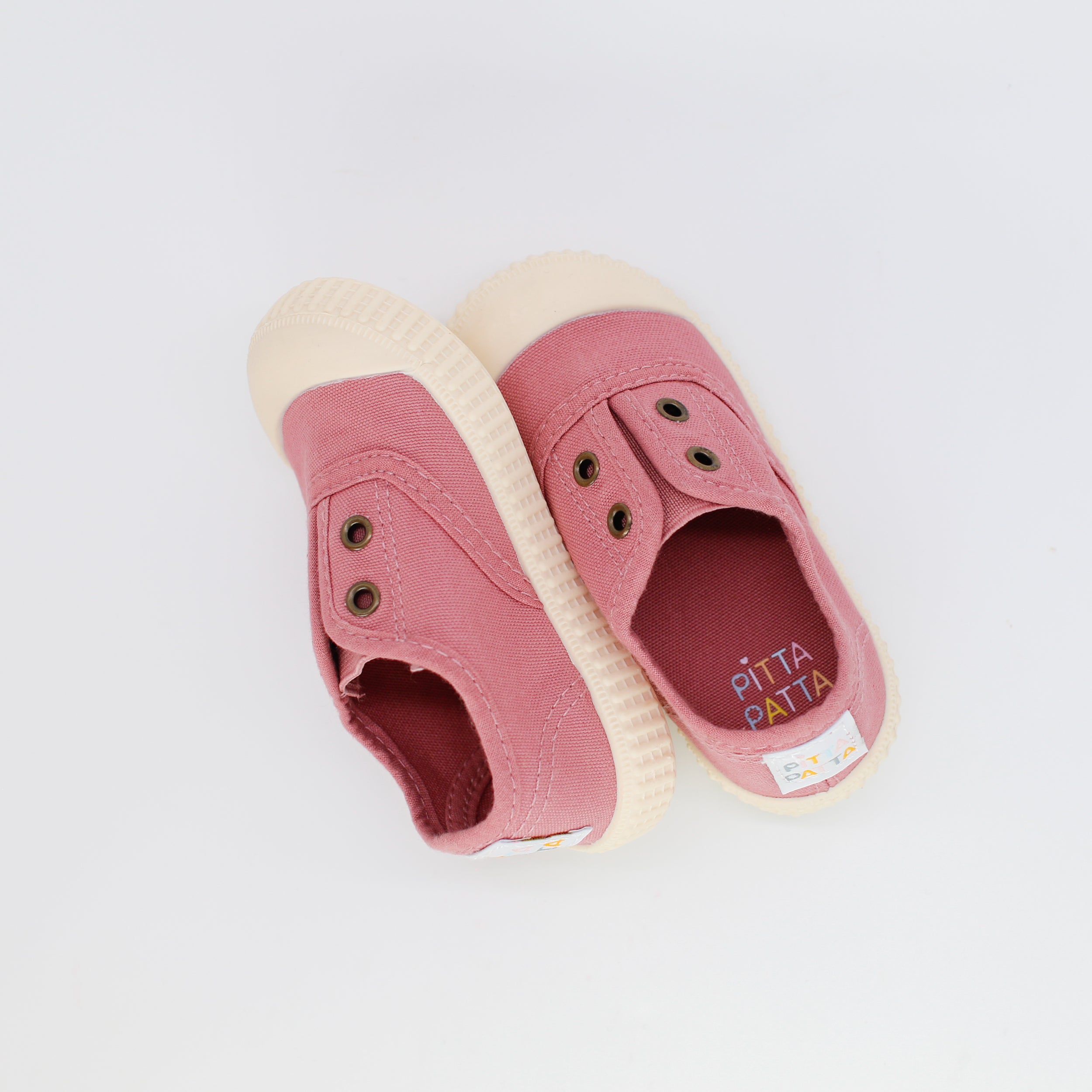 Pink slip-on shoes with beige soles on a white background