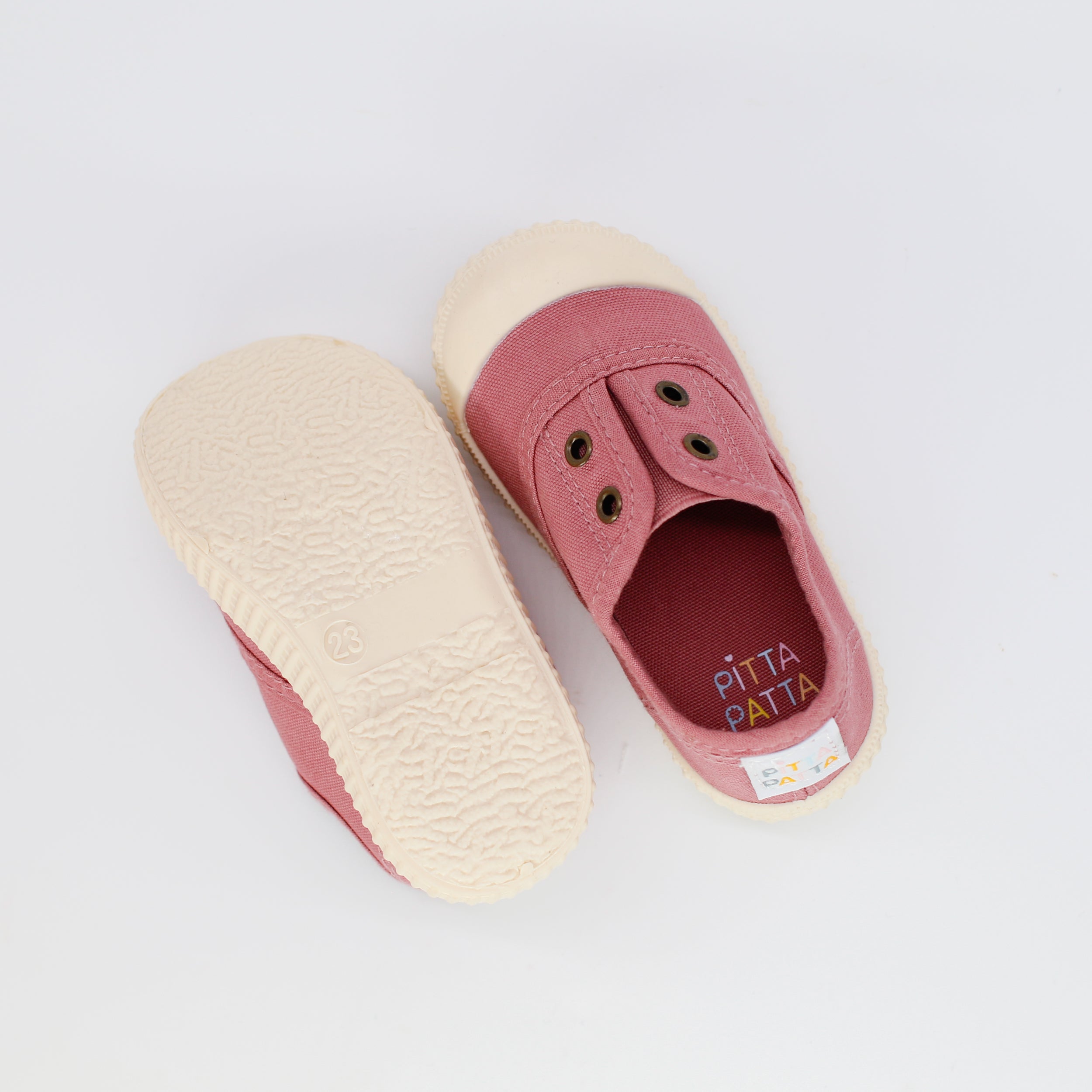 Pink slip-on shoes with white soles on a light gray background