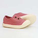 Pink children's shoes with white soles on a light gray background