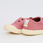 Pair of pink children's shoes with a visible brand label on a light background
