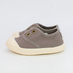 Baby shoe with beige sole on a white background