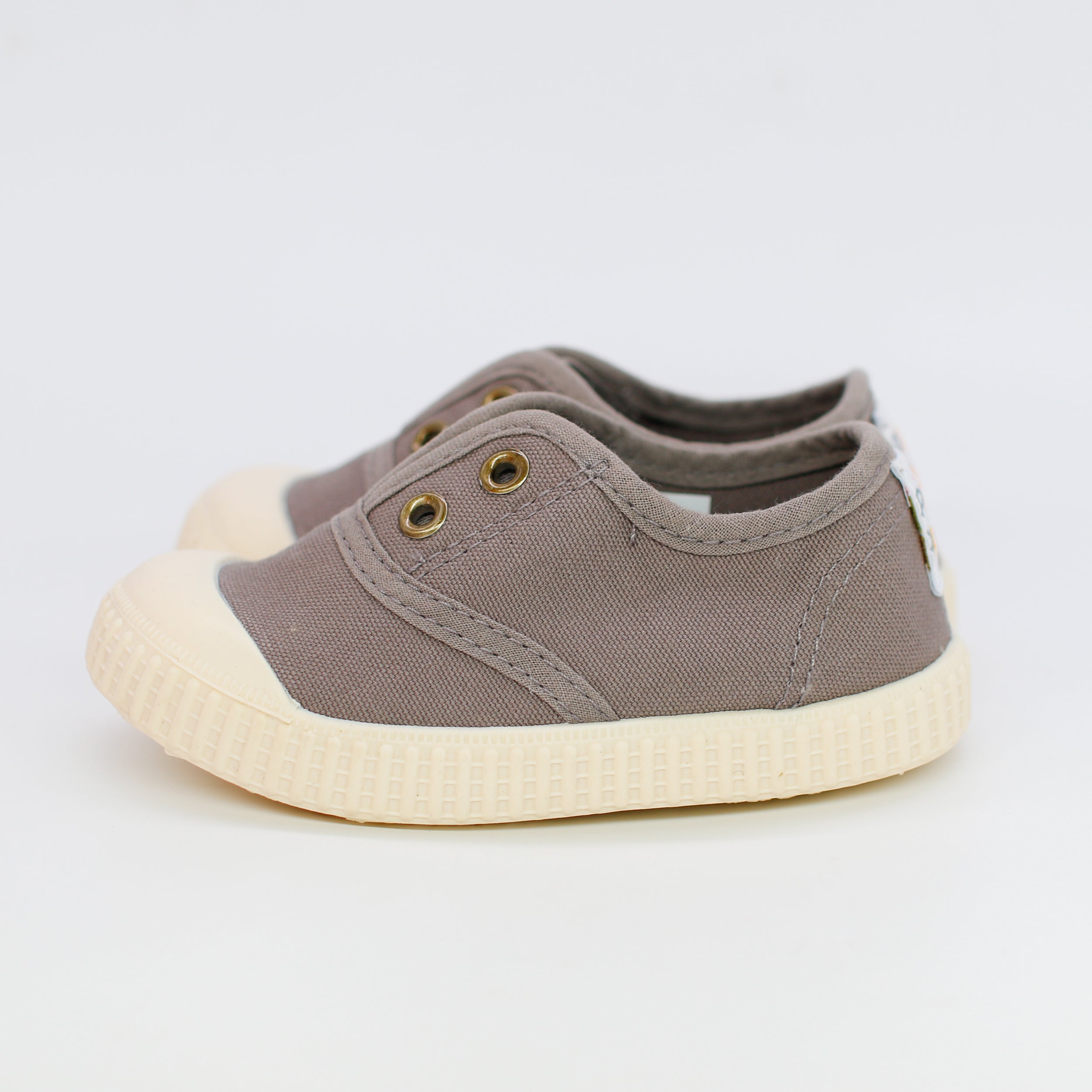 Baby shoe with beige sole on a white background