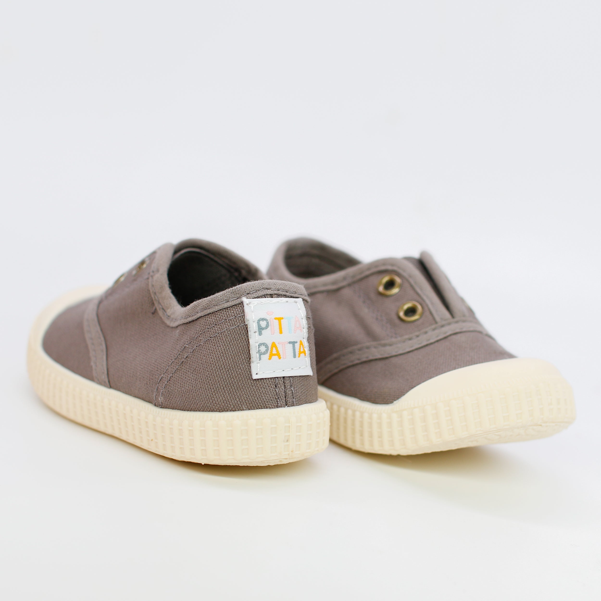 Pair of brown children's sneakers with a visible brand label on a white background