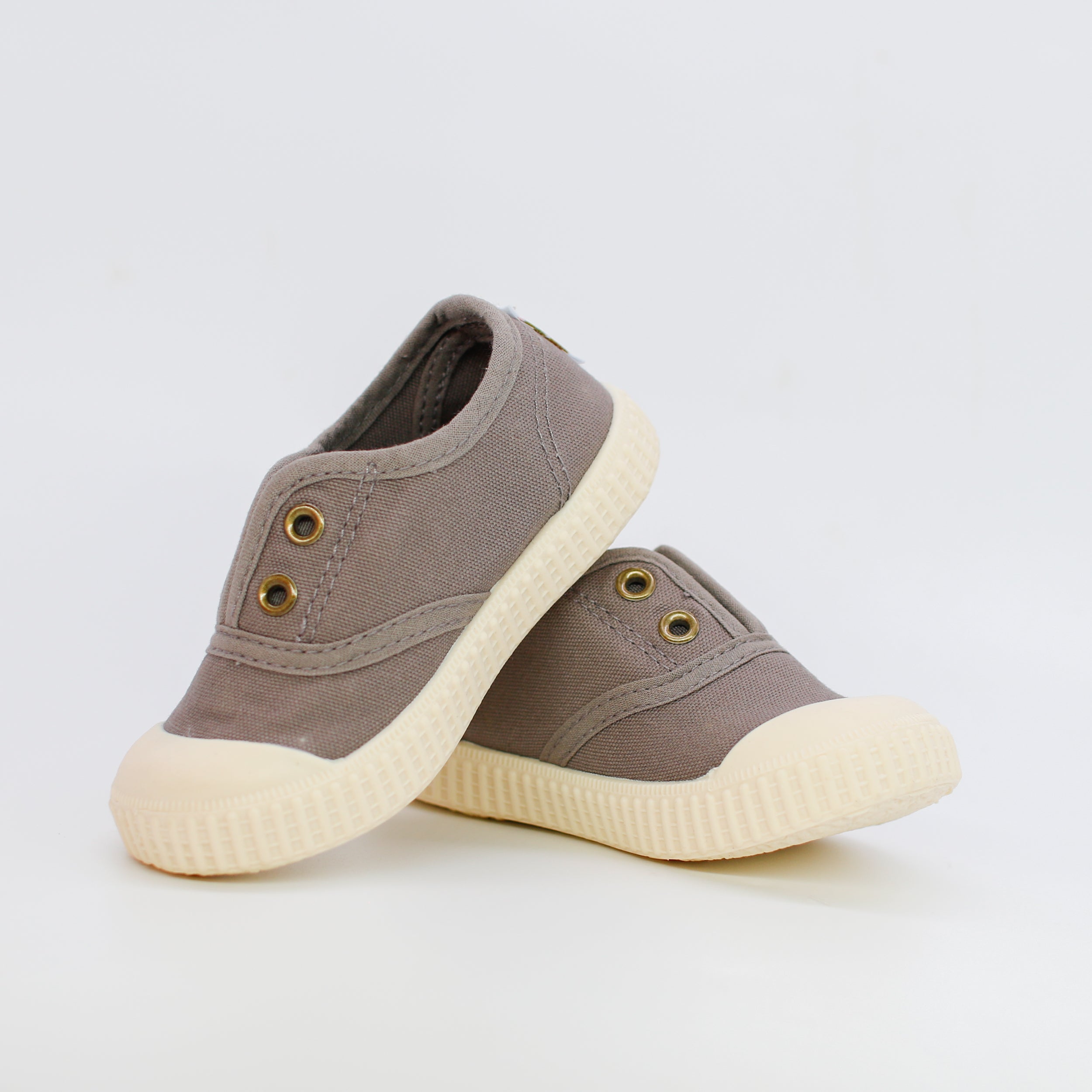 Pair of brown sneakers with white soles on a light gray background