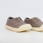 Pair of brown children's shoes with white soles on a light gray background