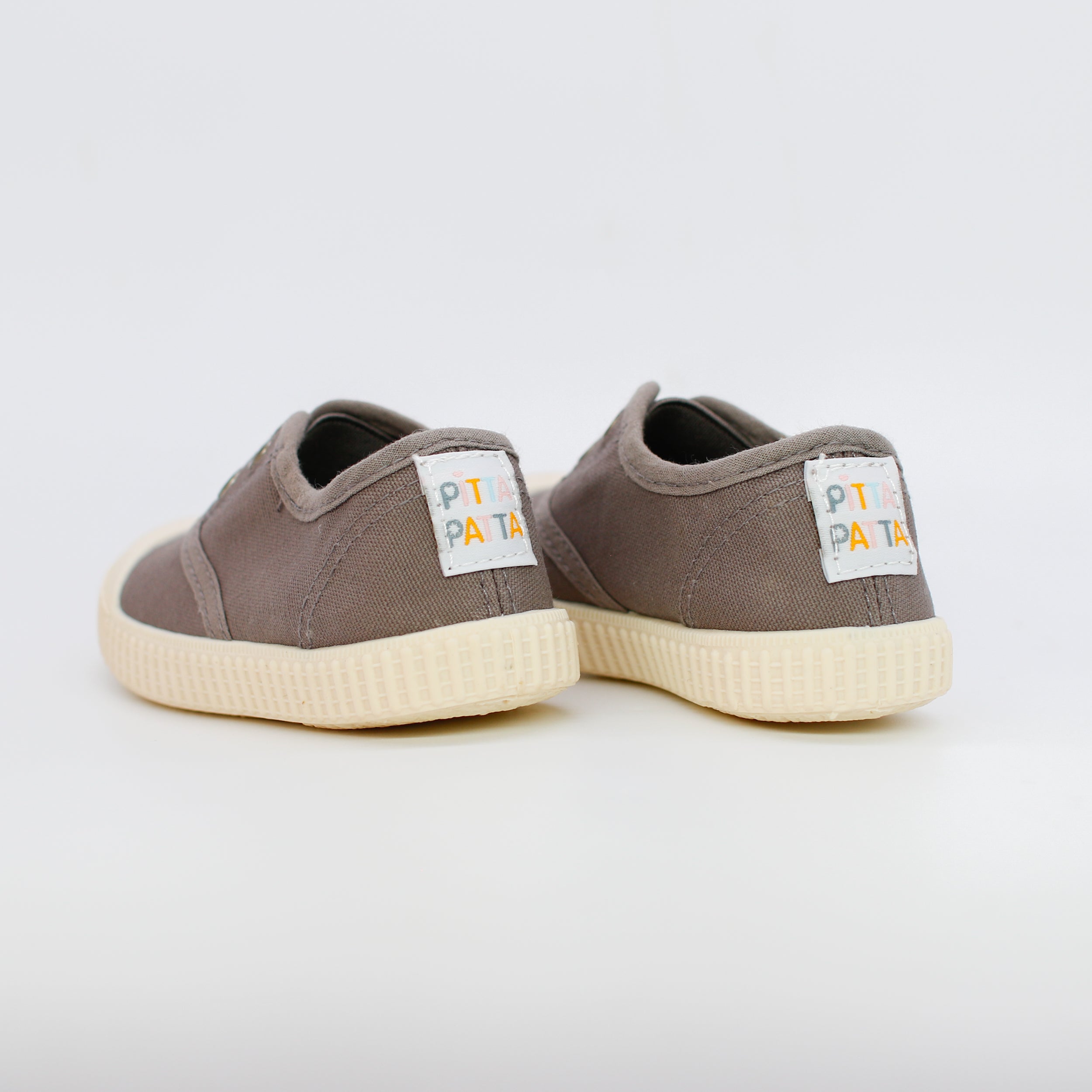 Pair of brown sneakers with white soles on a light gray background