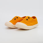 Pair of orange sneakers with white soles on a light gray background