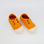 Pair of orange children's shoes on a white background