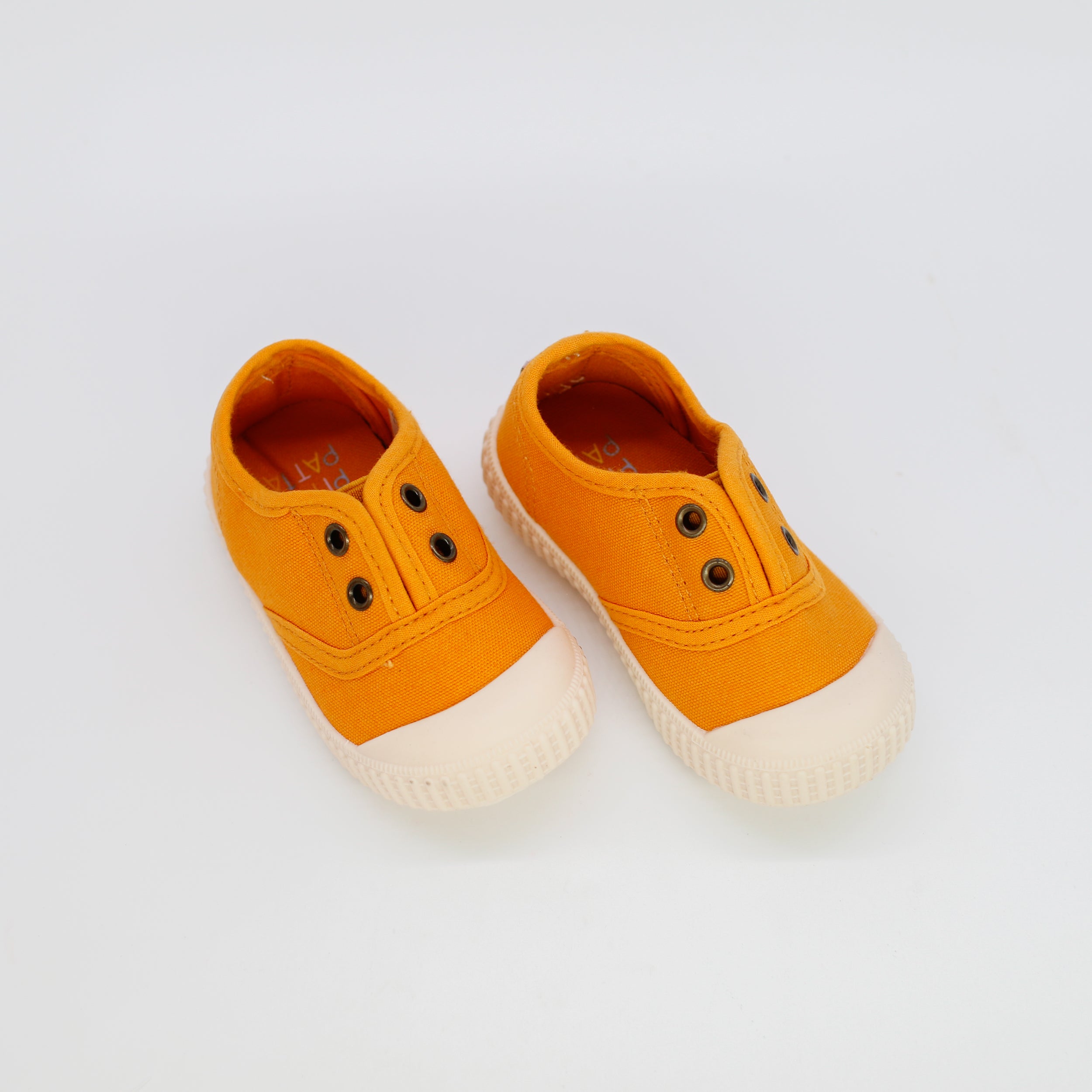 Pair of orange children's shoes on a white background