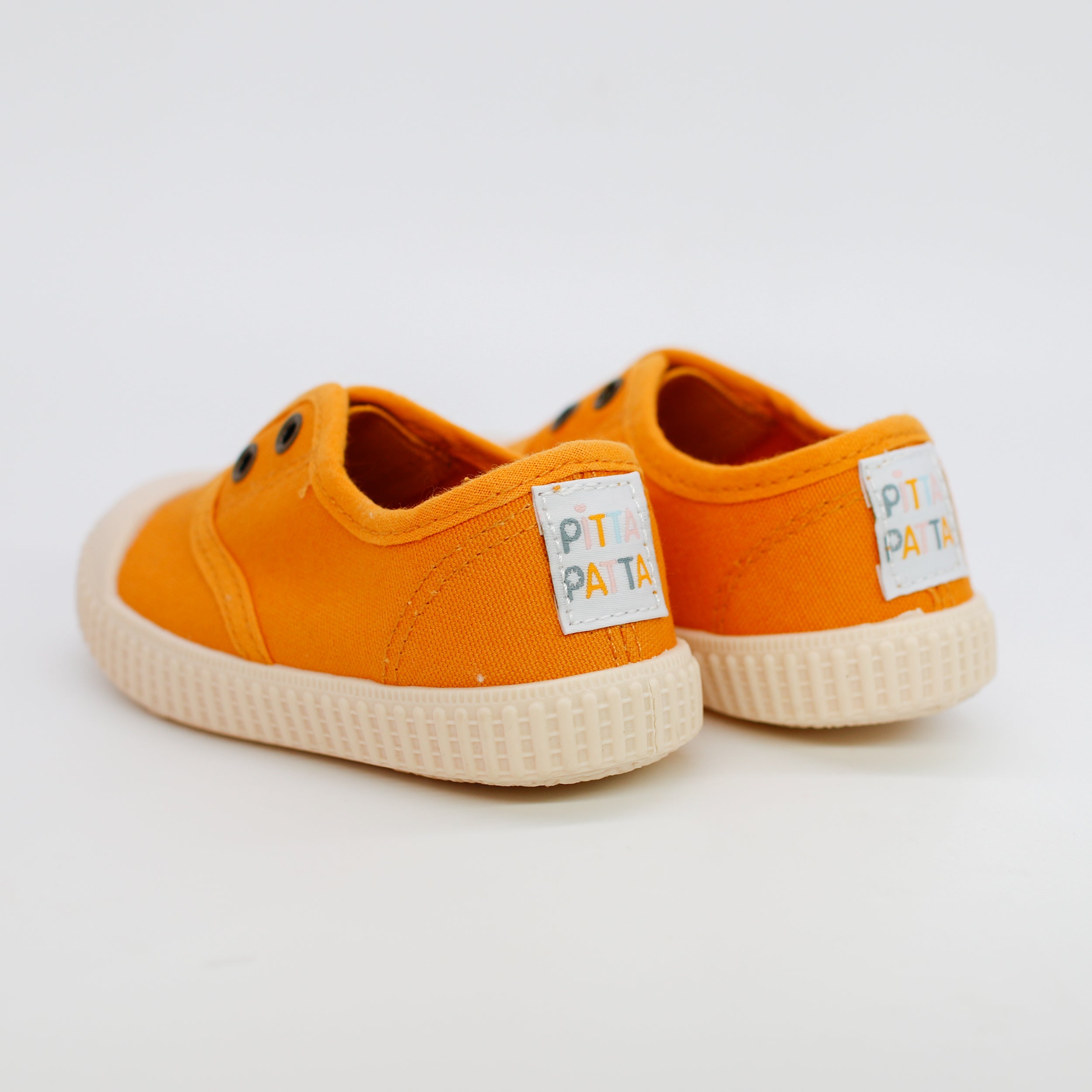 Orange children's shoes with 'Pipa' labels on a light gray background