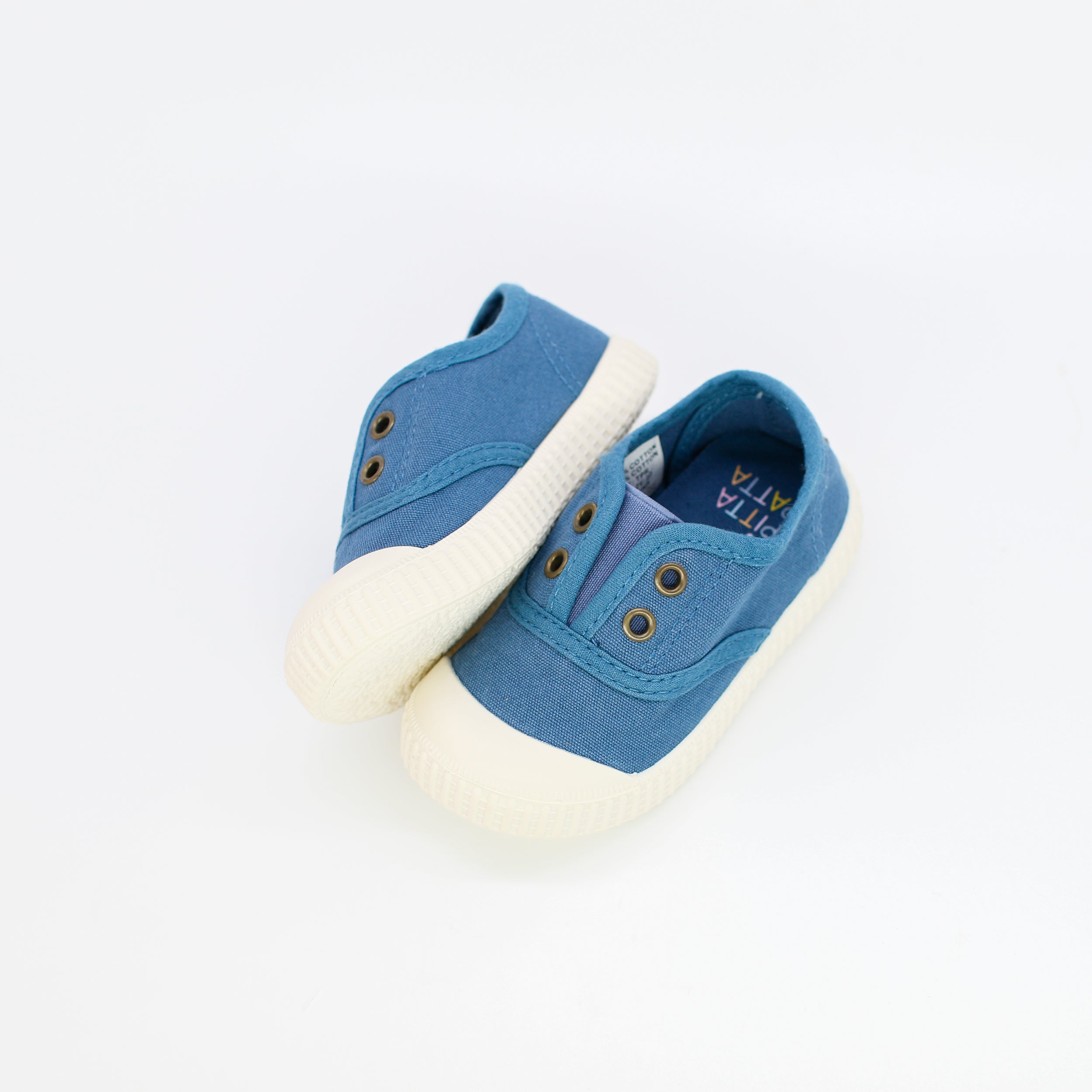 Blue baby shoes with white soles on a light gray background