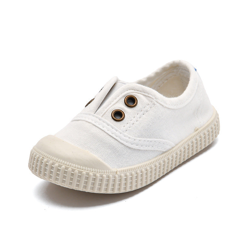 White children's sneaker with brown buttons on a white background