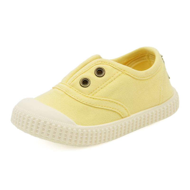 Yellow children's sneaker with a white sole on a white background